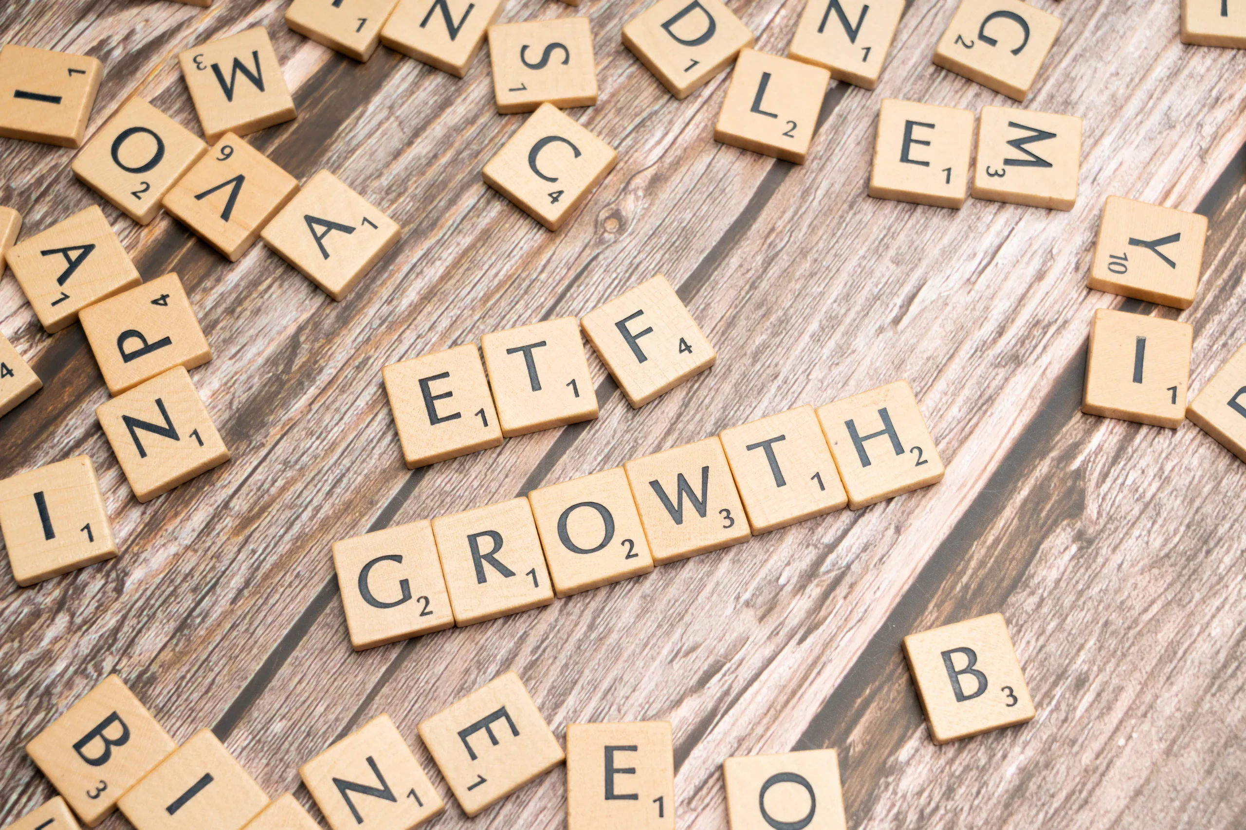 Scrabble tiles spelling out 'ETF Growth,' representing investment strategies which could be related to ESG investing course.