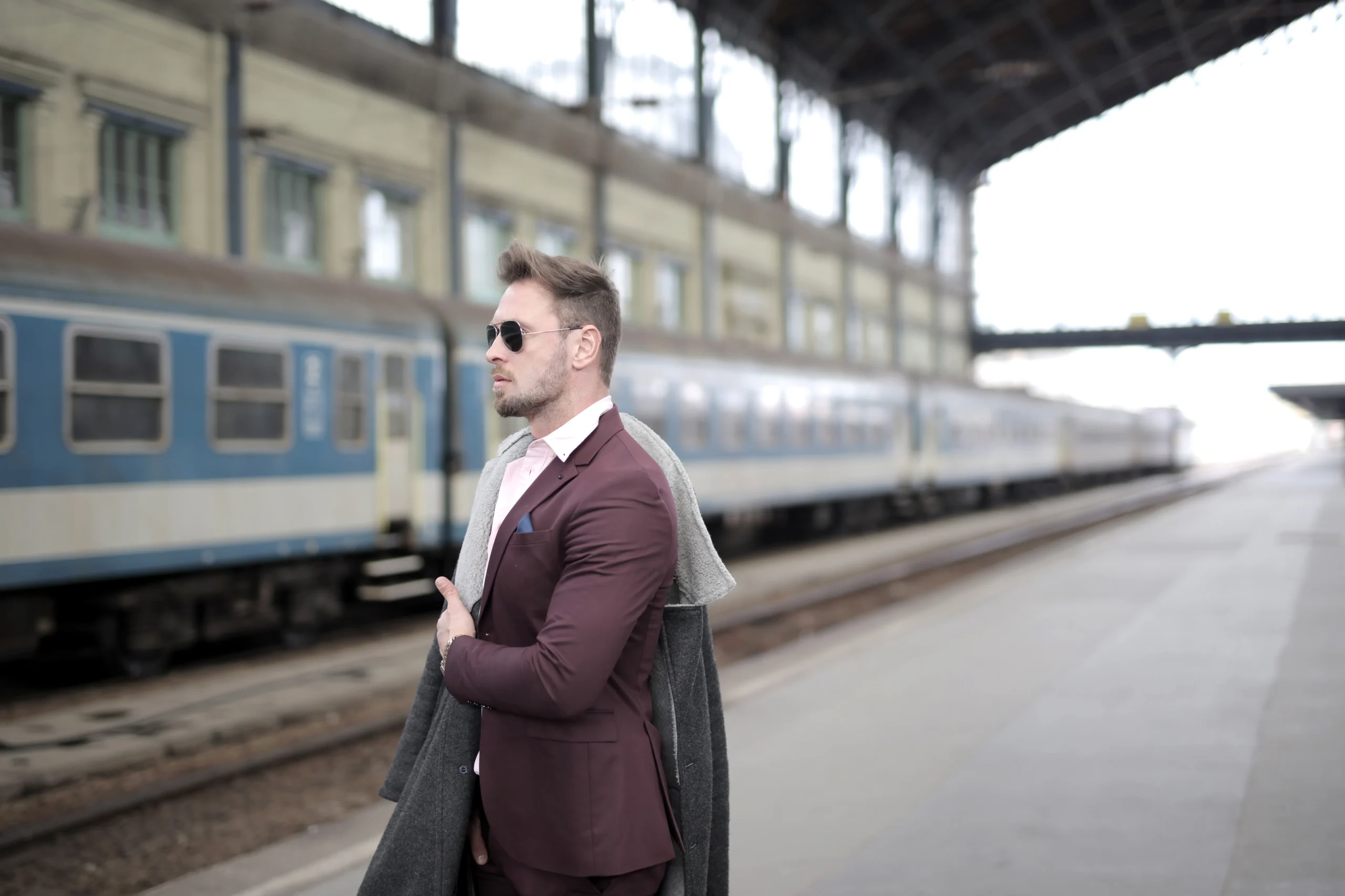 A person in a suit standing at a train station, possibly heading to or from ESG training or a job related to ESG.