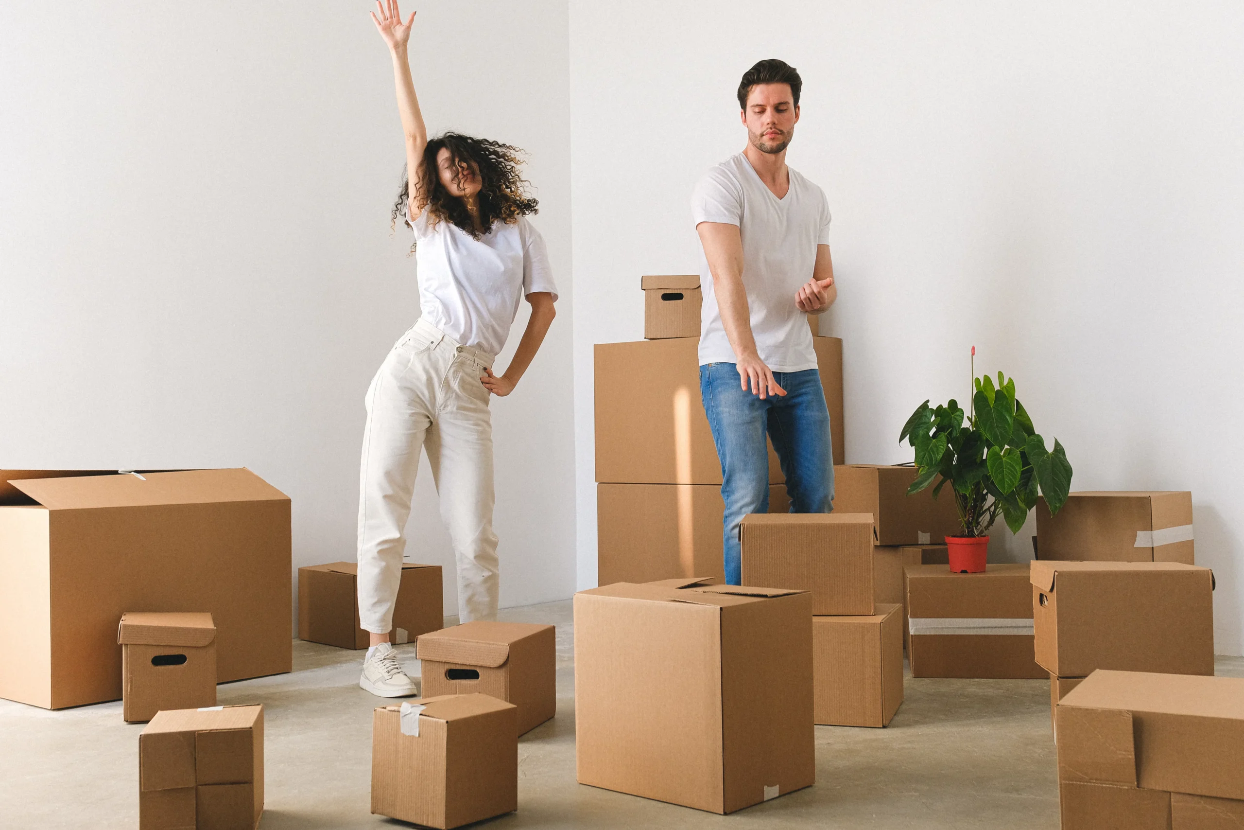 A couple surrounded by moving boxes, unrelated to ESG training courses, shows the excitement and stress of relocation.