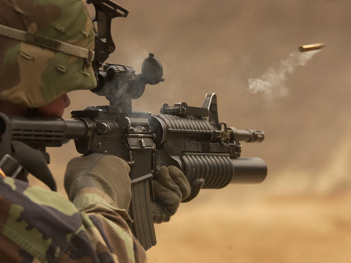 A soldier in camouflage firing a rifle, illustrating aspects of military training, though not directly related to ESG training courses or ESG certification.
