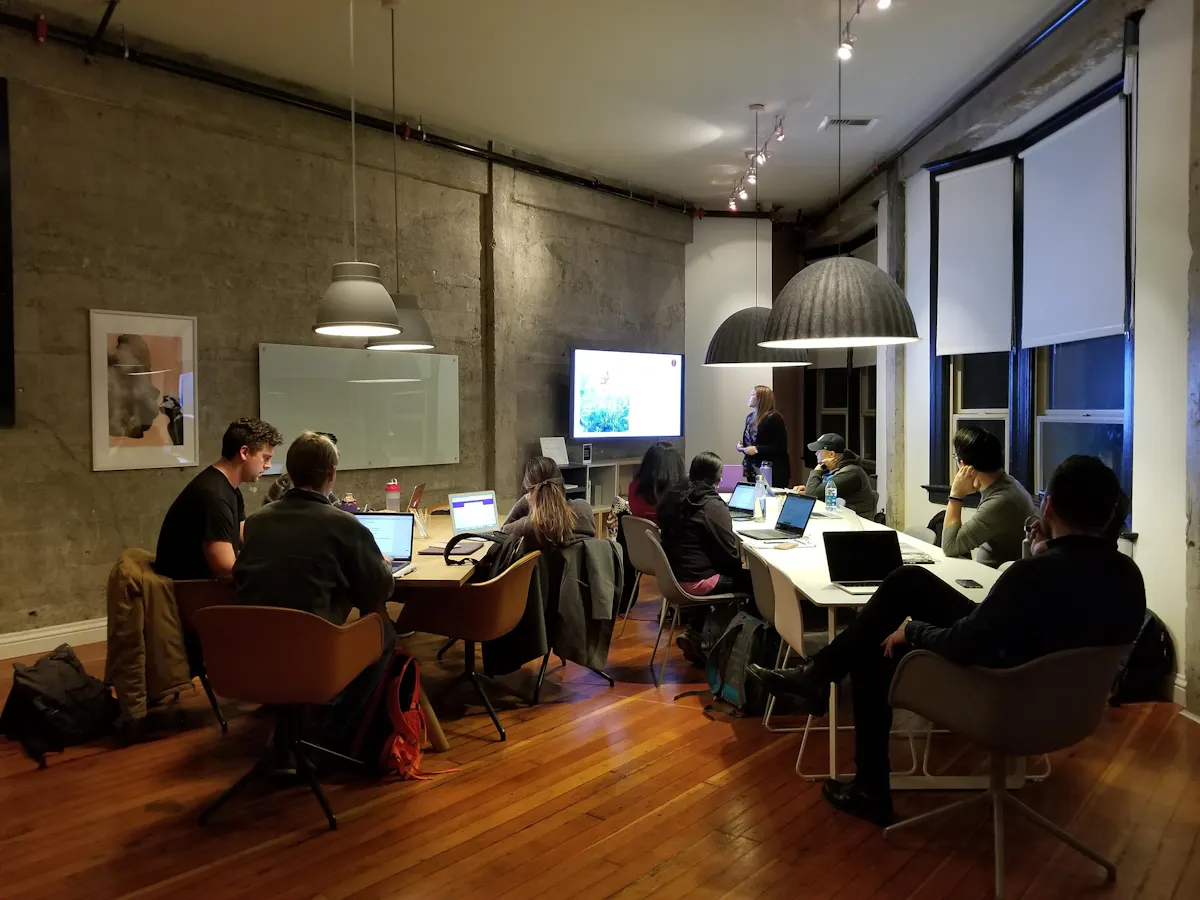 A group of professionals are gathered around a conference table for ESG training programs, possibly an ESG training for companies session, where they are learning how to boost their career with ESG knowledge by attending ESG courses online.