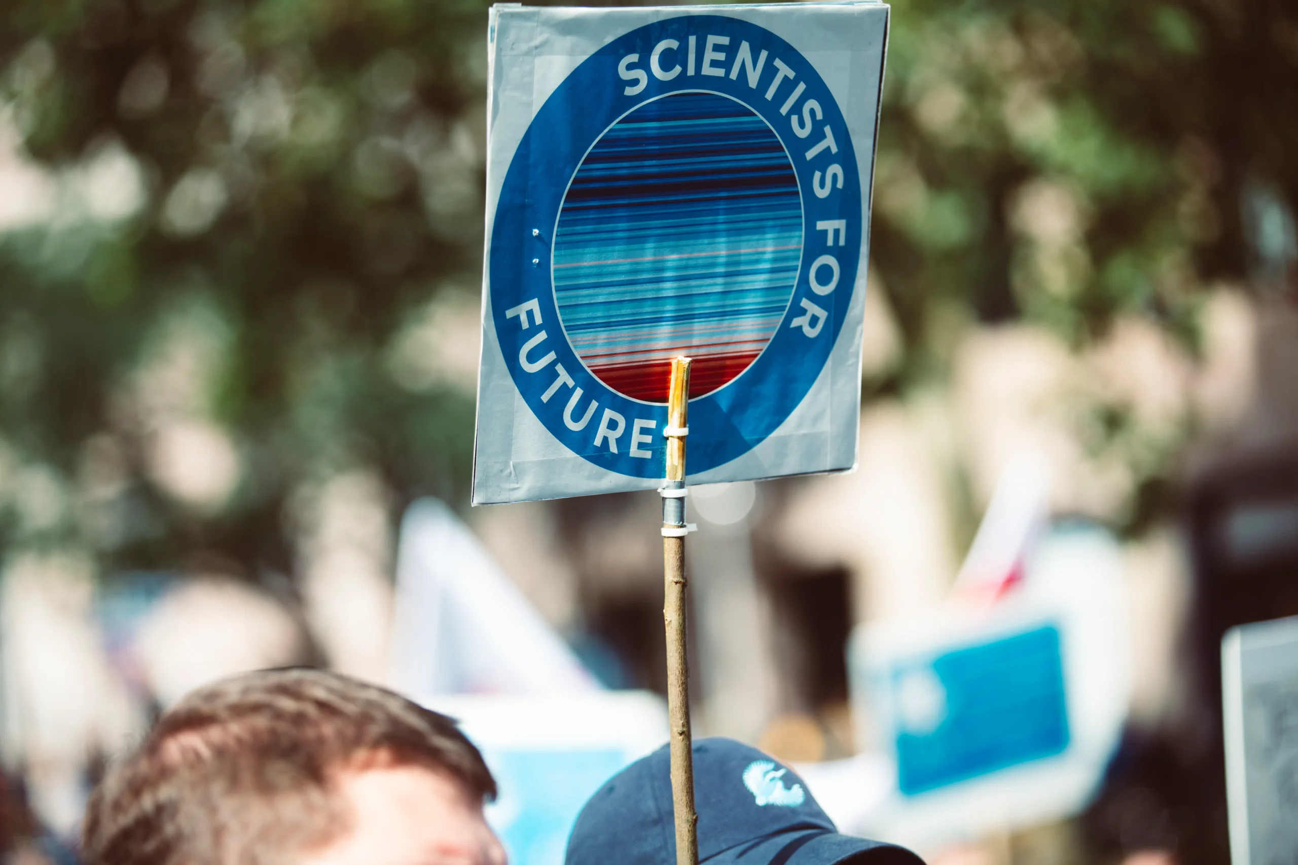 A sign reading 'Scientists for Future,' advocating for action on climate change, a critical issue addressed by environmental social governance consulting and sustainable business practices.