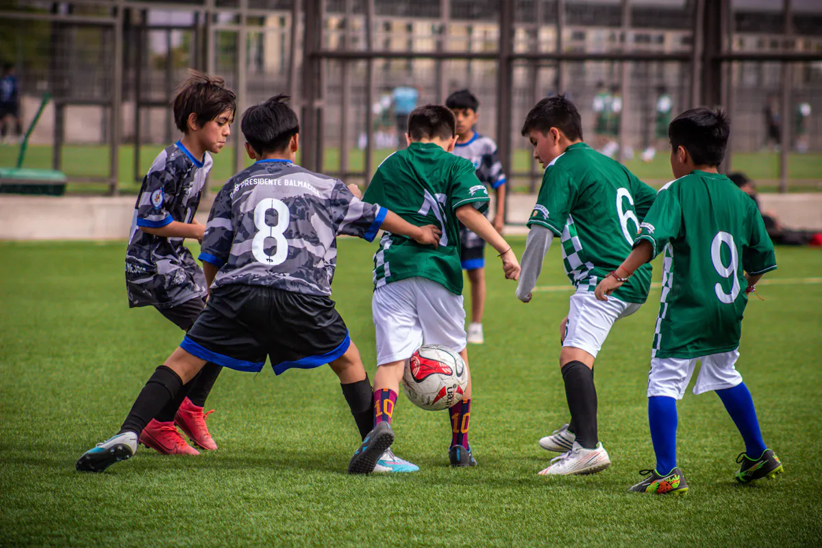 Youth soccer teams play a game on a green field, showcasing teamwork and physical activity.